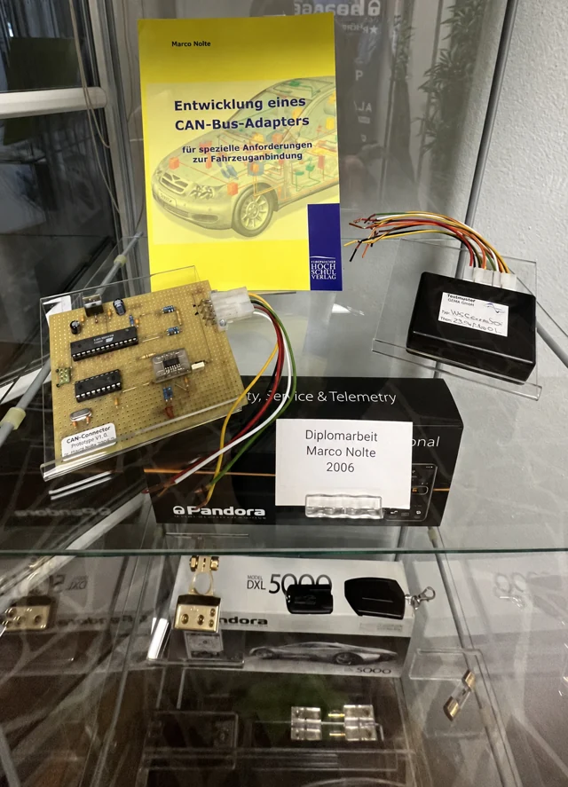 Vitrine mit der Diplomarbeit von Dipl.-Ing. (FH) Marco Nolte zur Entwicklung eines CAN-Bus-Adapters und elektronischen Bauteilen
