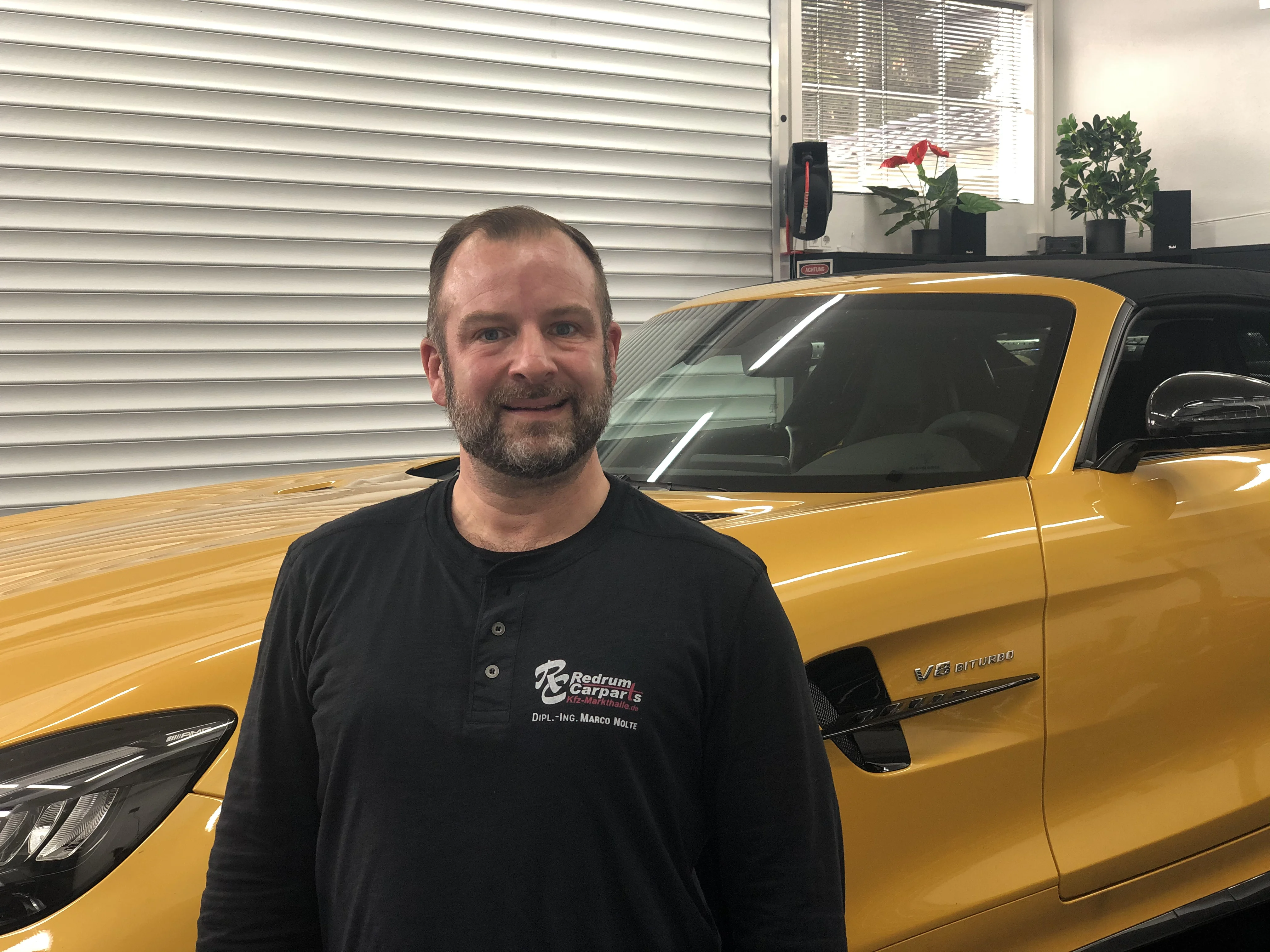 Marco Nolte vor einem gelben Mercedes in der Werkstatt