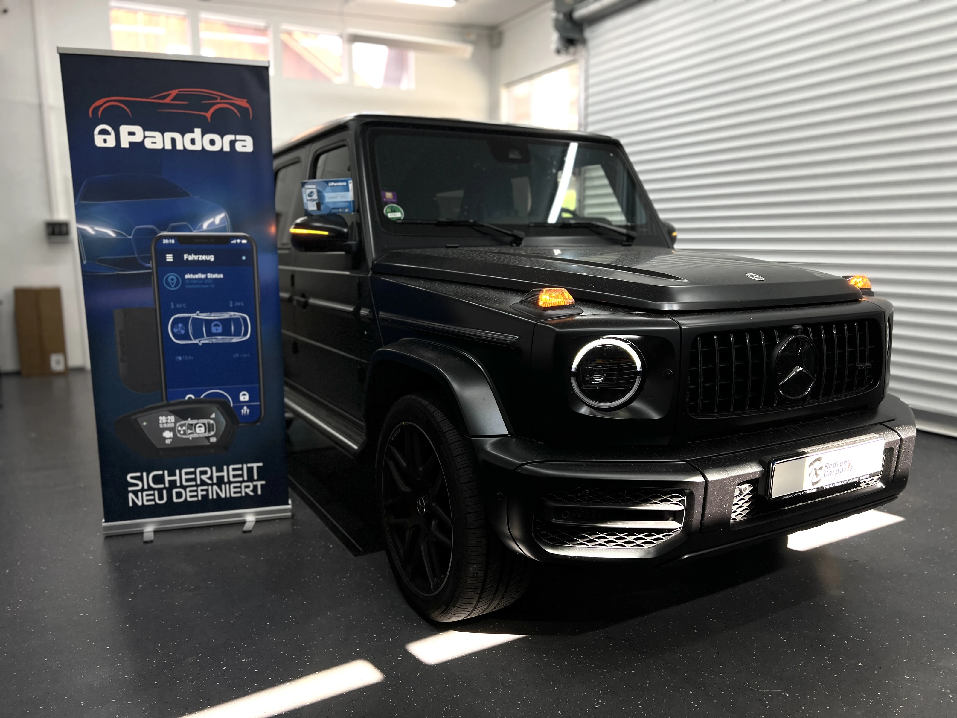 Mercedes G-Klasse neben dem Pandora-Aufsteller in unserer Werkstatt