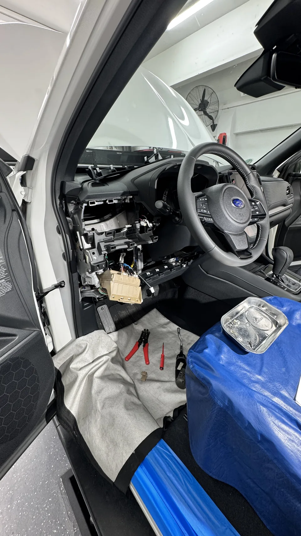 Arbeiten am Subaru Forester mit demontierter Verkleidung und geschütztem Innenraum