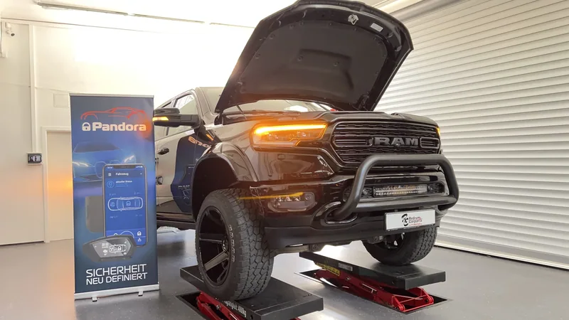 Dodge RAM mit geöffneter Motorhaube und leuchtenden Blinkern auf der Hebebühne bei Redrum Carparts.