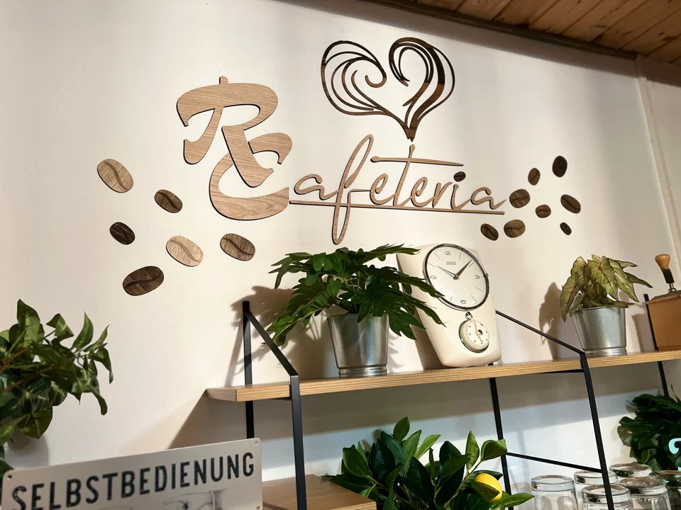 Cafeteria-Schriftzug mit Pflanzen und Dekoration